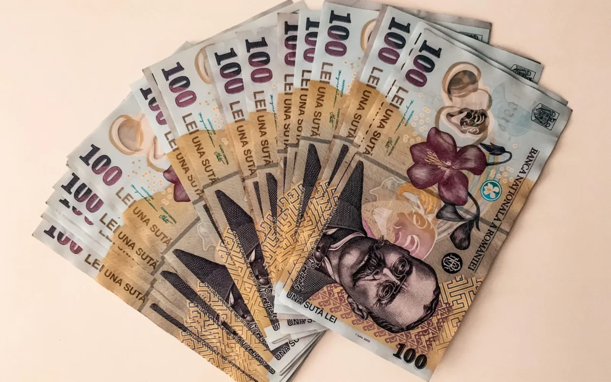 Bancnote românești de 100 de lei pe fundal bej