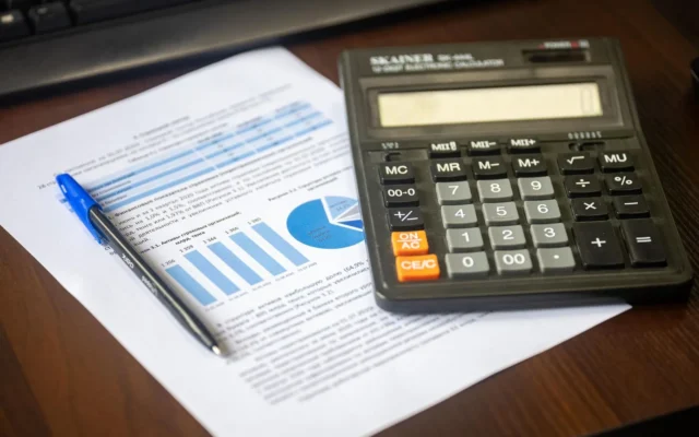 Calculator și pix pe un raport financiar