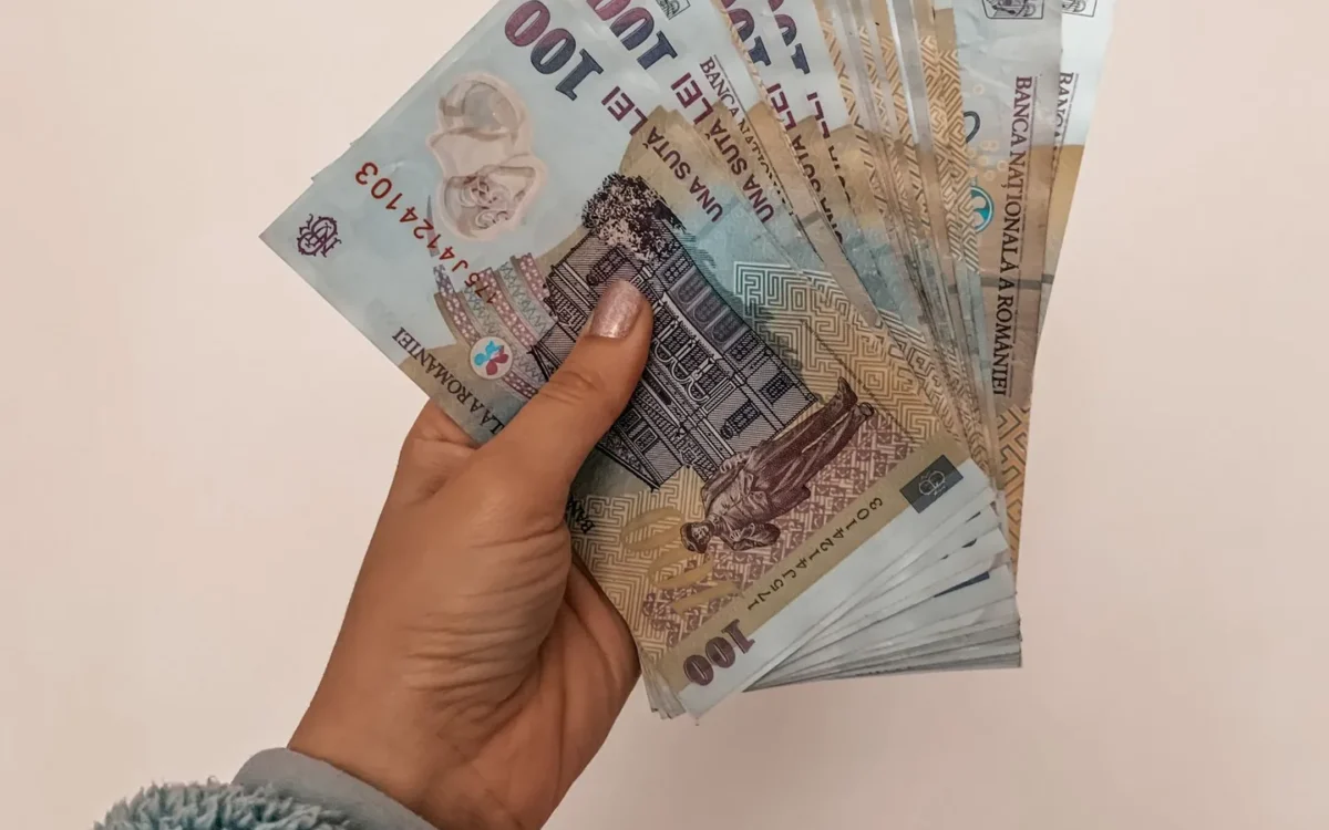 Mână care ține un evantai de bancnote românești