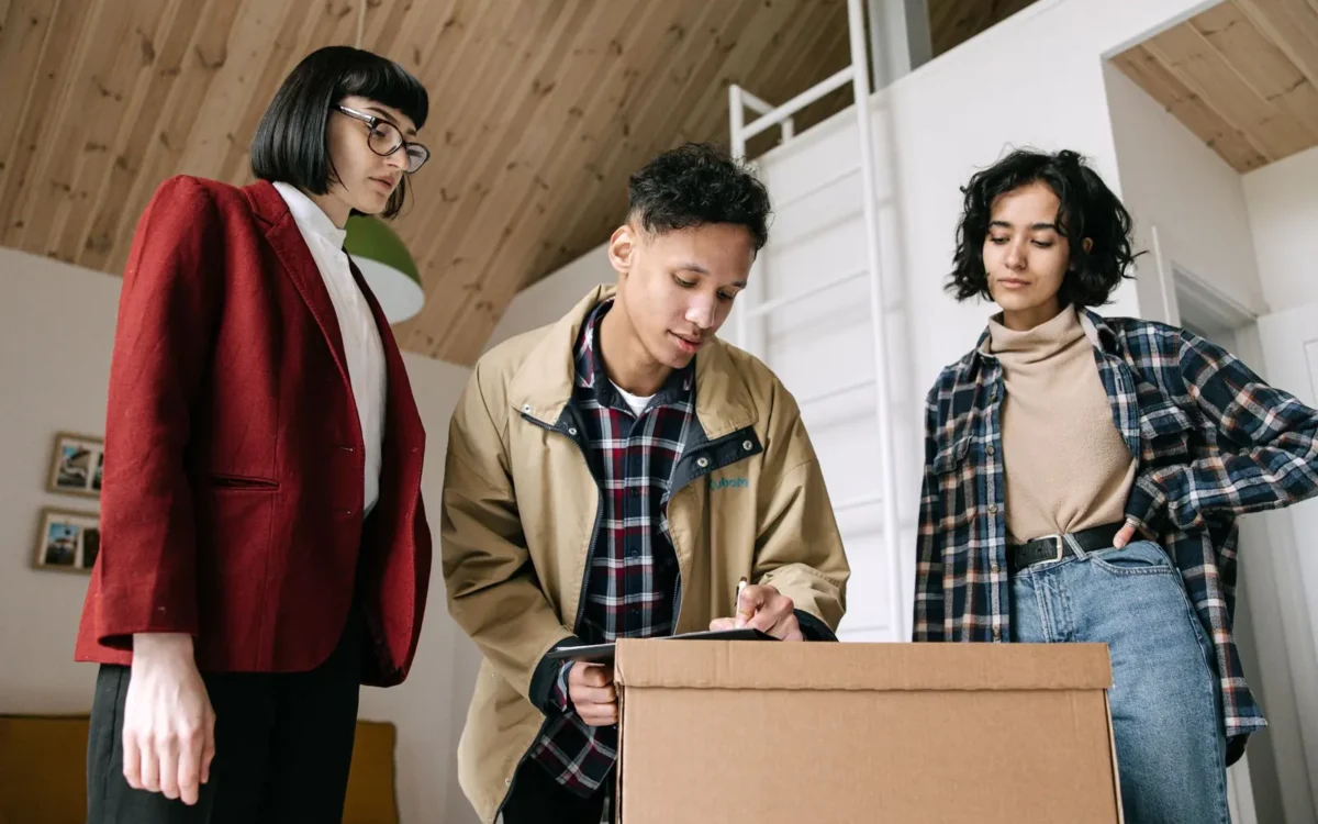 Persoană care semnează documente lângă două alte persoane